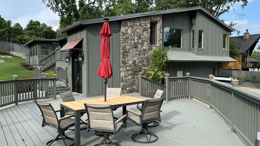 One of The Magnolia's two living-room decks, with swivel dining chairs above the yard