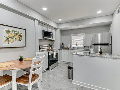 The in-unit laundry with a full-size washer and dryer against marble-look tile