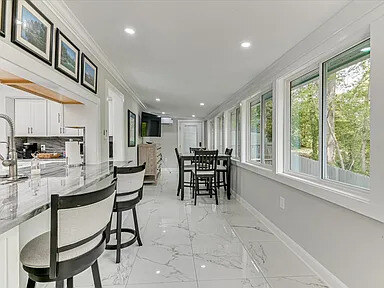 Second angle on The Magnolia's kitchen showing the range, hood, and marble backsplash