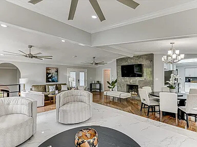 The Magnolia's sprawling living room with hardwood floors, pale sofas, and windows onto the treetops