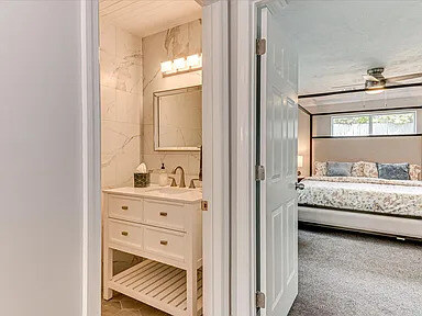 The master bath's walk-in shower, glass-enclosed beside the double vanity and separate from the tub